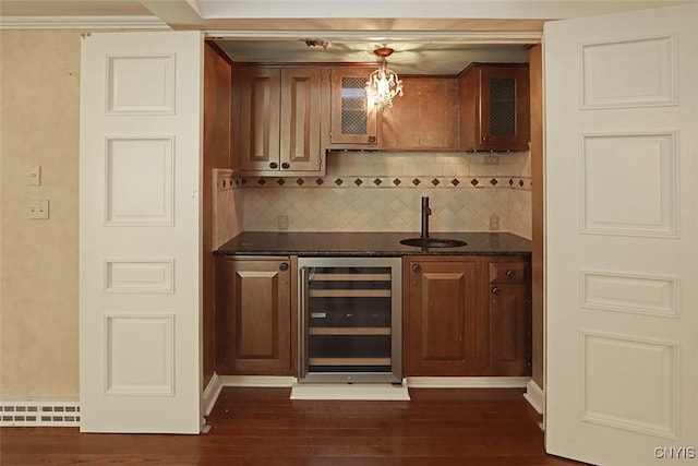 bar featuring decorative light fixtures, sink, beverage cooler, and dark hardwood / wood-style floors