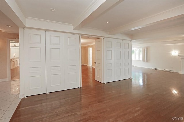 unfurnished bedroom featuring dark tile patterned flooring, crown molding, and beamed ceiling