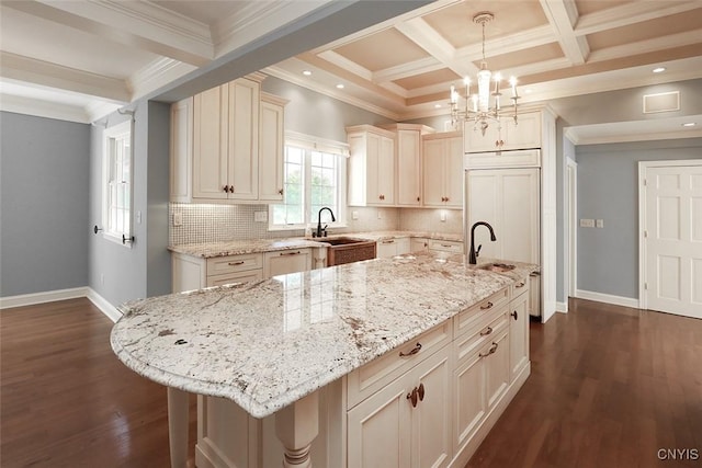 kitchen with pendant lighting, sink, a kitchen island, coffered ceiling, and beamed ceiling