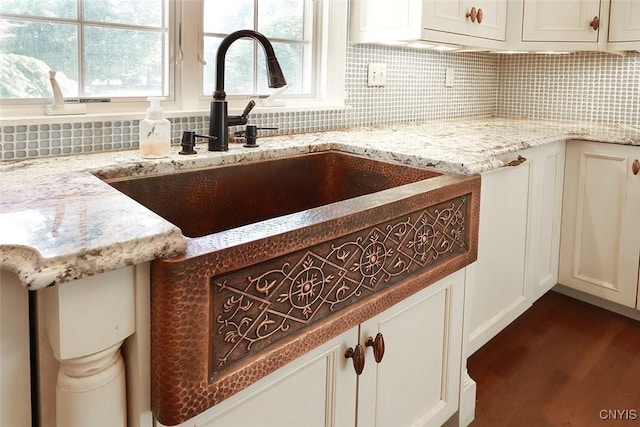 kitchen with sink, light stone counters, dark hardwood / wood-style floors, and decorative backsplash