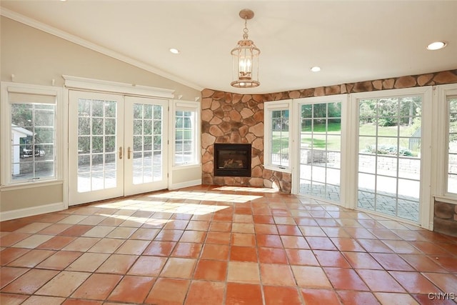 unfurnished living room with plenty of natural light, vaulted ceiling, and french doors