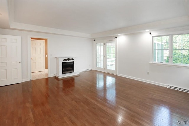 unfurnished living room featuring wood-type flooring and crown molding