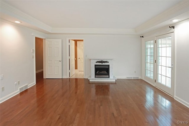 unfurnished living room with wood-type flooring, a high end fireplace, and ornamental molding