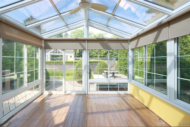 unfurnished sunroom featuring ceiling fan, plenty of natural light, and lofted ceiling