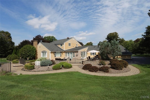 rear view of house with a patio area and a lawn