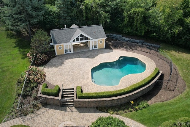 view of pool featuring a lawn and a patio