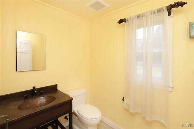 bathroom featuring vanity, toilet, and ornamental molding