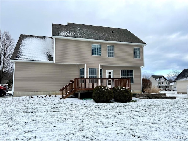 snow covered house with a deck