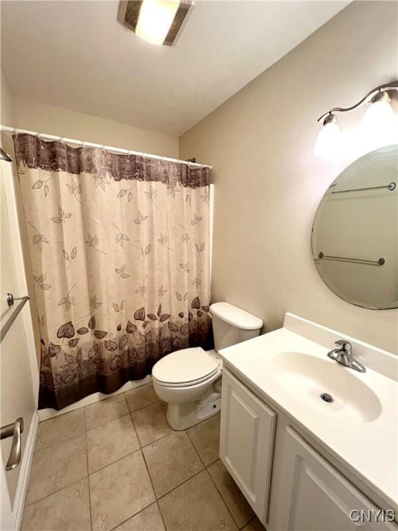 bathroom with tile patterned floors, vanity, toilet, and walk in shower