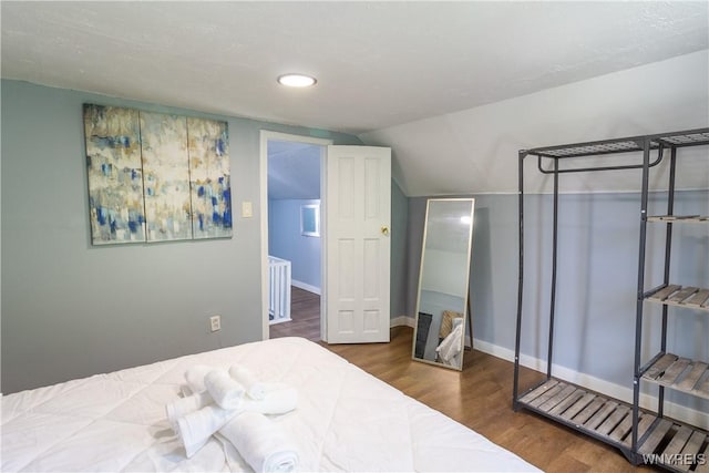 bedroom featuring dark wood-type flooring and lofted ceiling