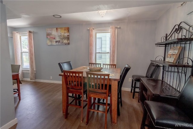 dining space featuring dark hardwood / wood-style flooring and an inviting chandelier