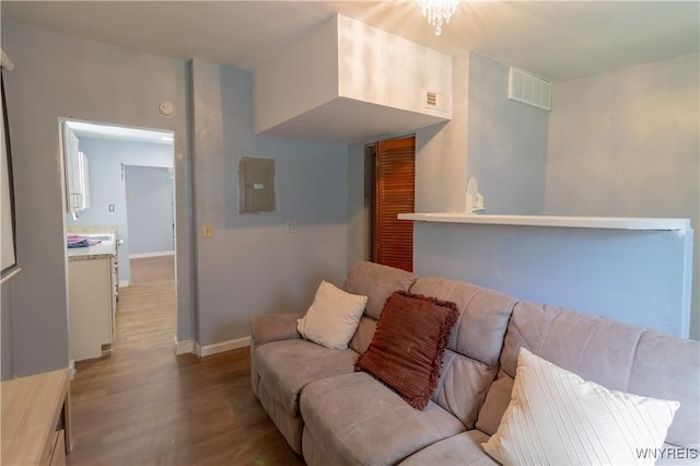 living room with electric panel and light hardwood / wood-style flooring