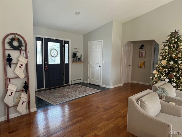 foyer entrance featuring dark hardwood / wood-style flooring, baseboard heating, and lofted ceiling