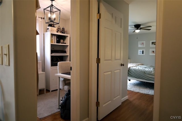 hall with dark hardwood / wood-style flooring and a notable chandelier