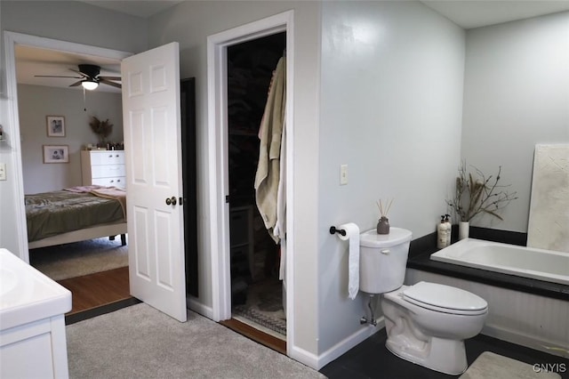 bathroom with vanity, toilet, ceiling fan, and a bathing tub