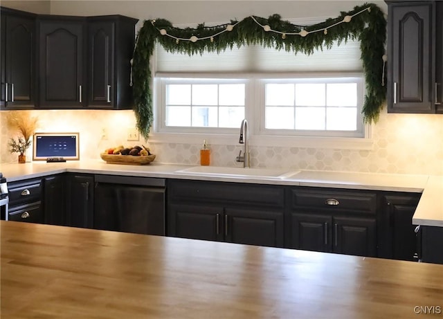 kitchen with decorative backsplash, a wealth of natural light, dishwasher, and sink