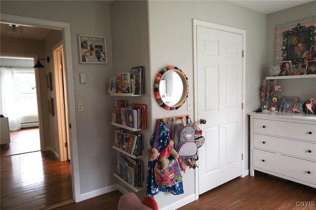 bedroom with baseboard heating and dark wood-type flooring