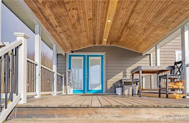 view of exterior entry with a deck and french doors