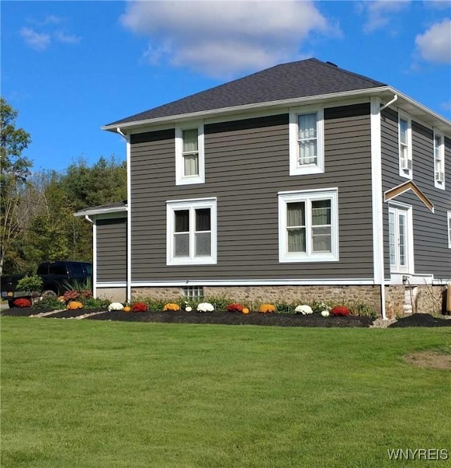 view of side of home with a yard