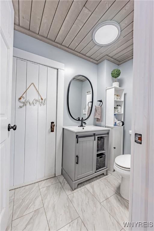 bathroom with vanity, toilet, wooden ceiling, and crown molding