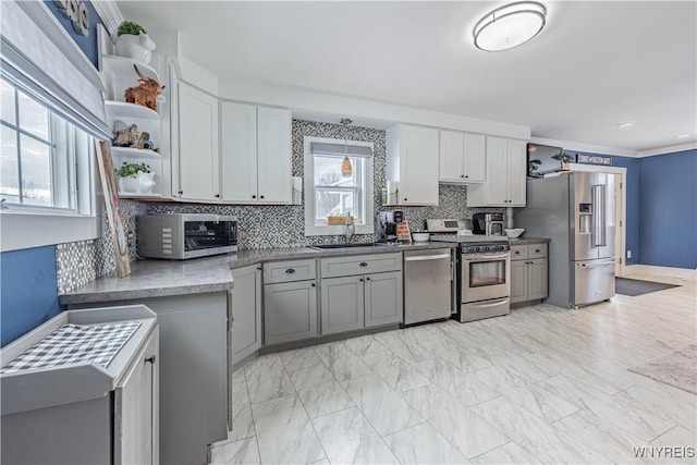 kitchen featuring decorative backsplash, appliances with stainless steel finishes, gray cabinetry, crown molding, and sink