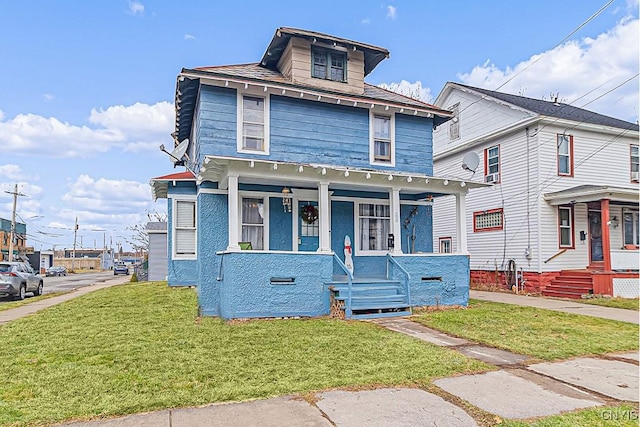 view of property featuring covered porch and a front yard