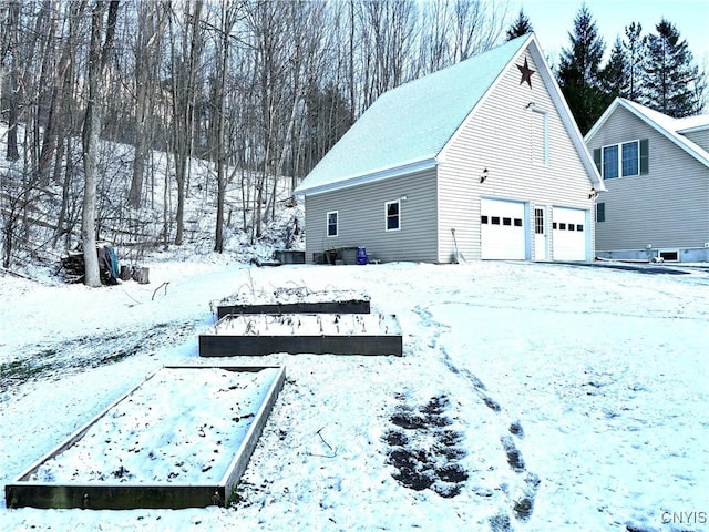 yard covered in snow featuring a garage