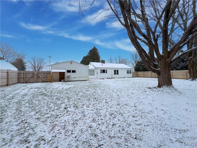 view of snow covered back of property