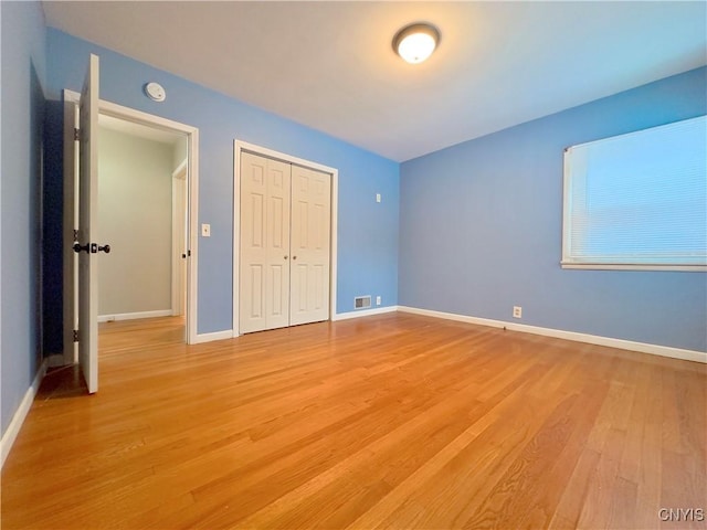 unfurnished bedroom with light hardwood / wood-style flooring and a closet