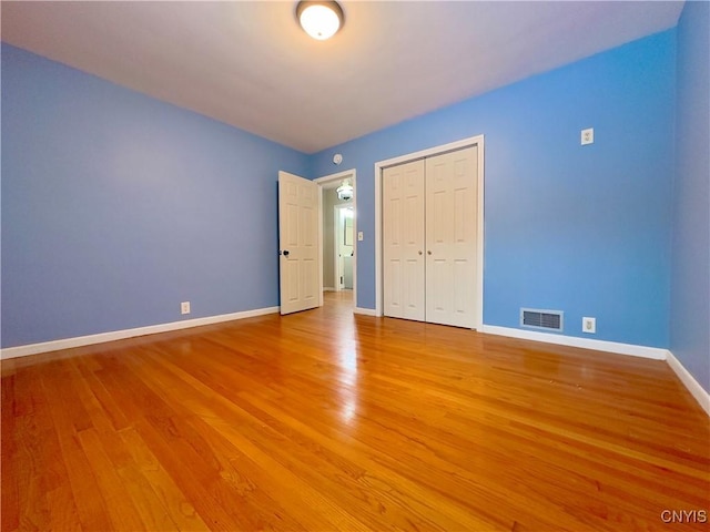 unfurnished bedroom with hardwood / wood-style flooring and a closet