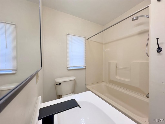 bathroom with bathtub / shower combination and toilet