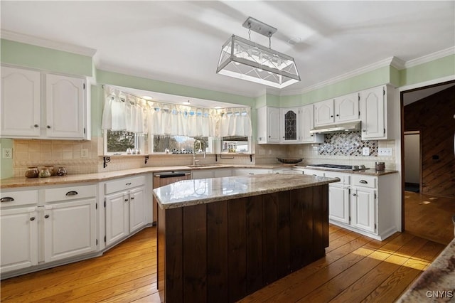 kitchen with white cabinets, a kitchen island, sink, and light hardwood / wood-style flooring