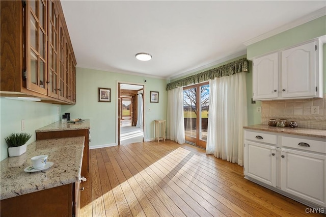 kitchen featuring white cabinets, light wood-type flooring, and ornamental molding