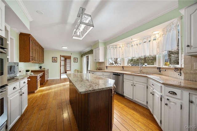 kitchen featuring a kitchen island, light stone counters, white cabinetry, and stainless steel appliances