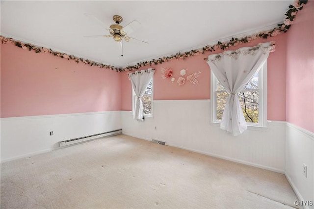 carpeted spare room with ceiling fan and a baseboard radiator