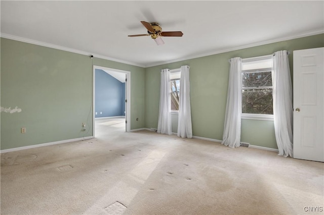 carpeted spare room with ceiling fan and ornamental molding