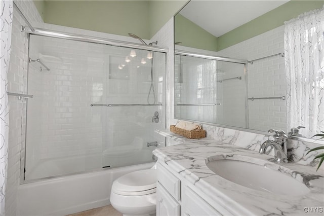 full bathroom with shower / bath combination with glass door, vanity, and toilet