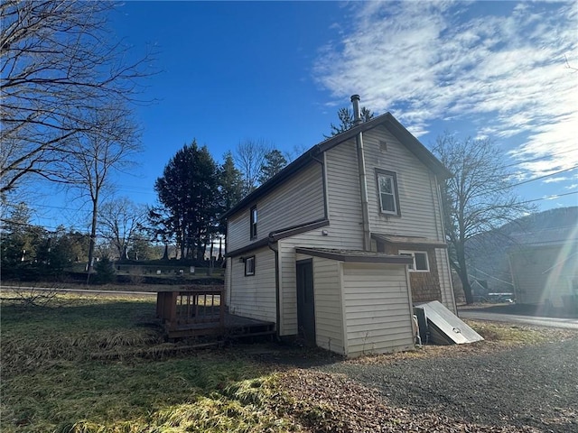 rear view of property featuring a wooden deck