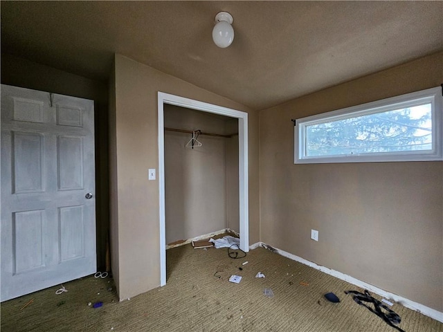 unfurnished bedroom featuring lofted ceiling and a closet