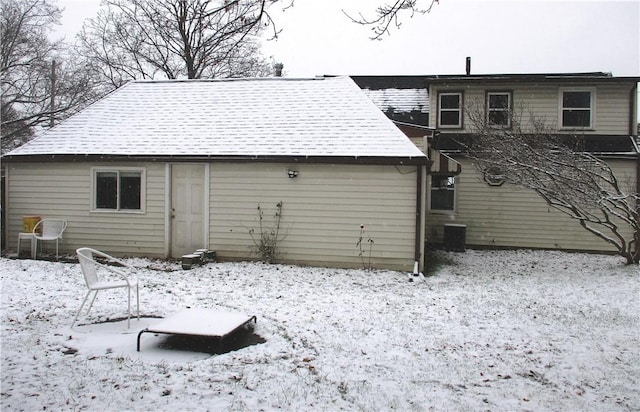 snow covered rear of property with central AC unit