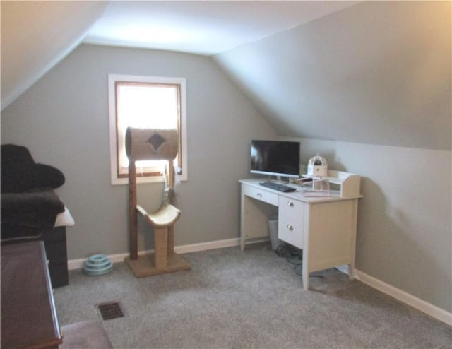 carpeted home office with vaulted ceiling