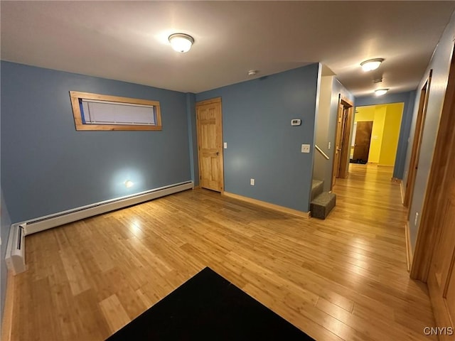 spare room with a baseboard radiator and light hardwood / wood-style floors