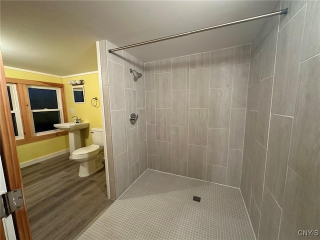 bathroom with a tile shower and toilet