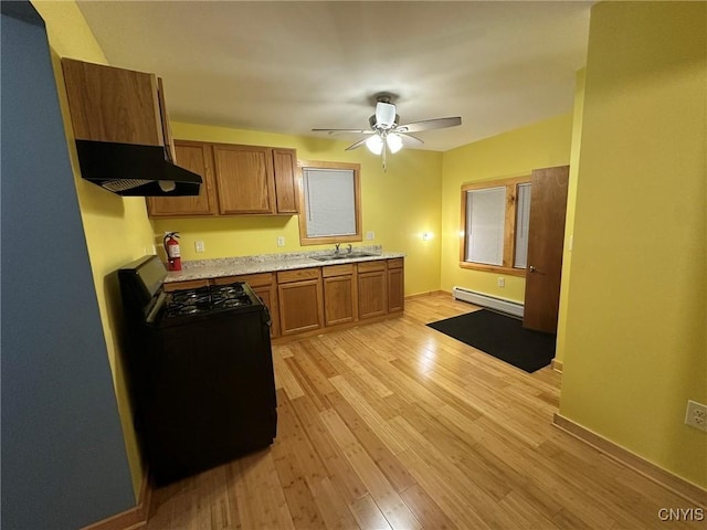 kitchen with ceiling fan, sink, a baseboard heating unit, light hardwood / wood-style floors, and black range