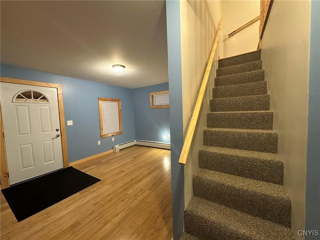 foyer entrance with wood-type flooring and a baseboard radiator