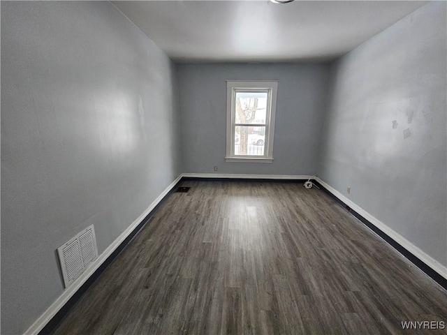 empty room with dark hardwood / wood-style flooring