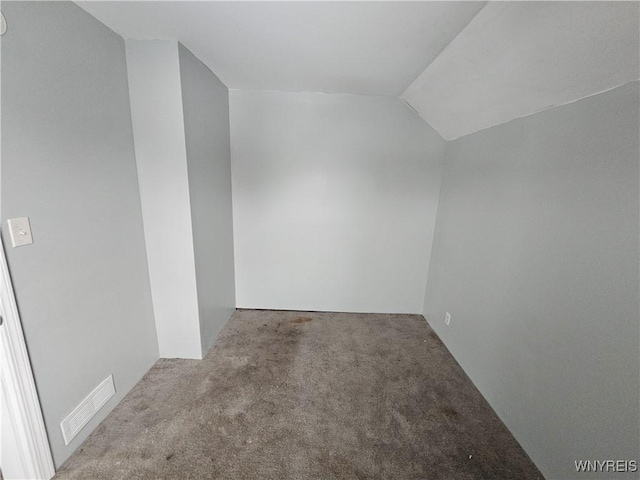 carpeted empty room featuring lofted ceiling