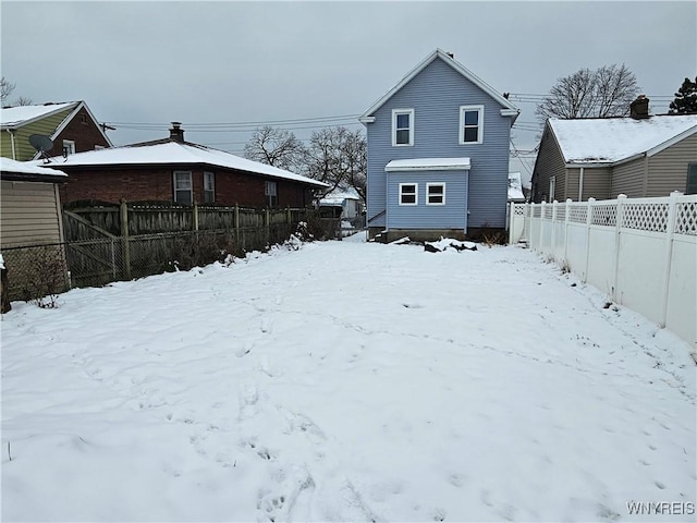 view of snow covered rear of property