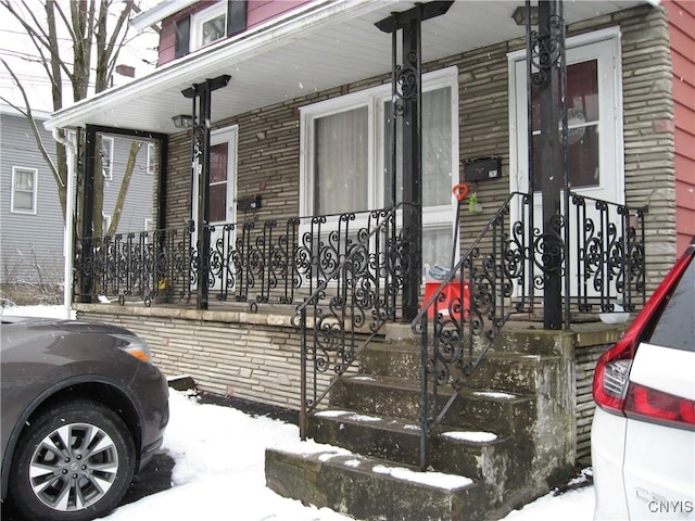 view of snowy exterior featuring a porch