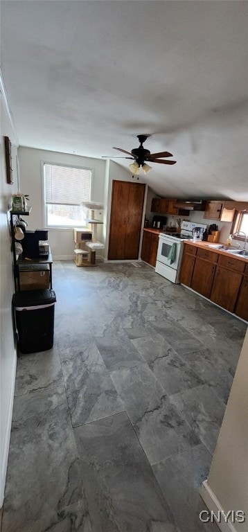 kitchen with a sink, a ceiling fan, brown cabinetry, and white range with electric cooktop